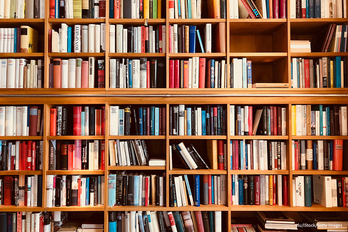 A photograph shows a bookshelf filled with stacks of books.