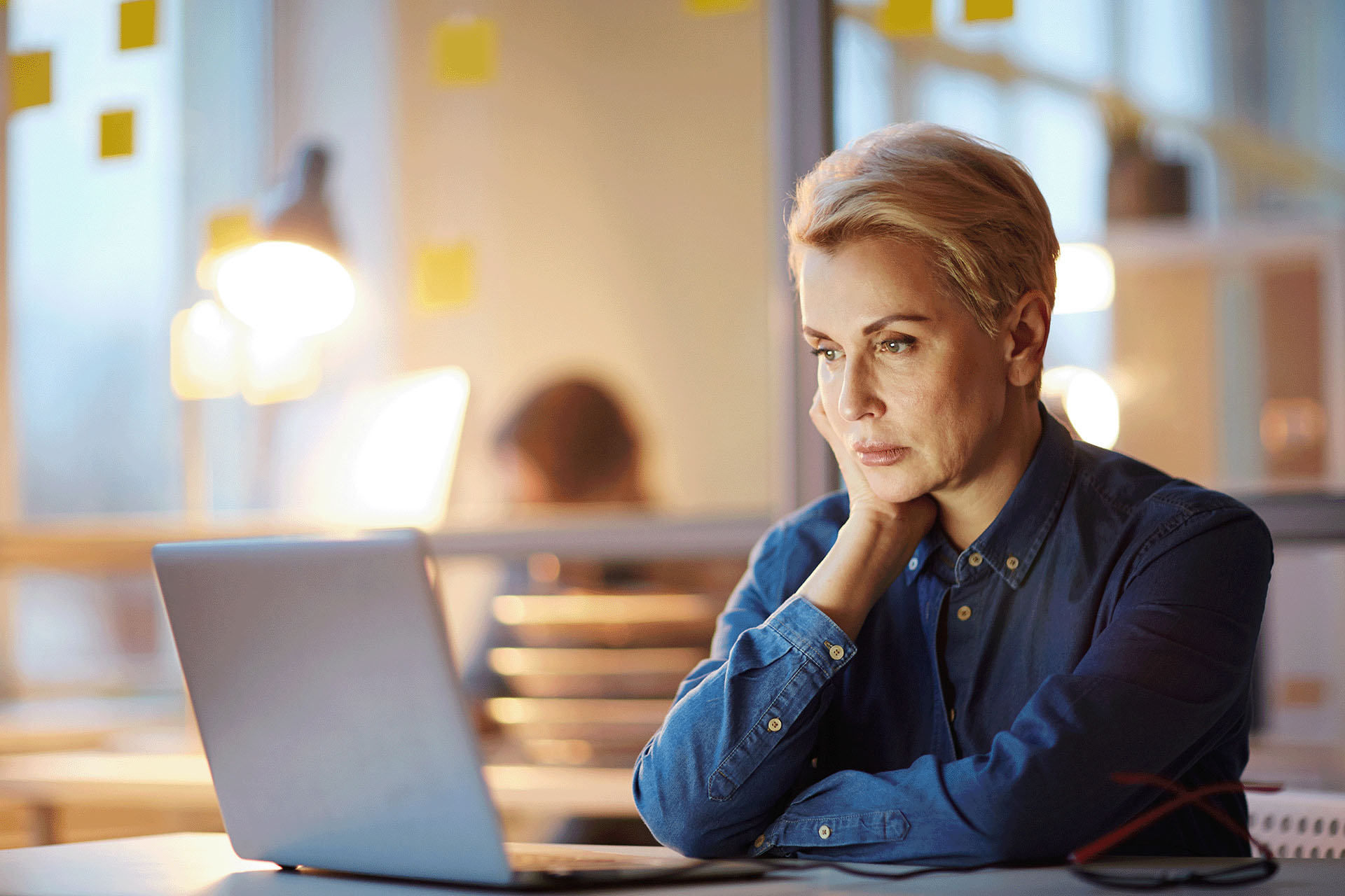 Woman sitting at a desk looking at a laptop