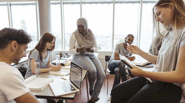 5 students working together in a classroom.