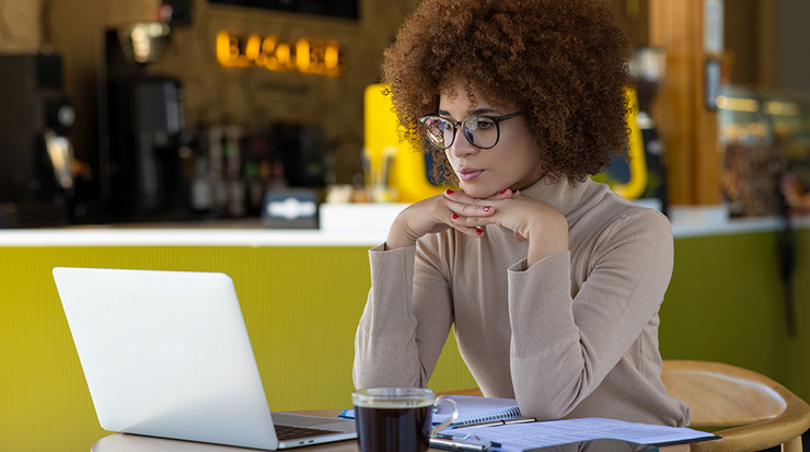 A woman sitting in a café working on her laptop.