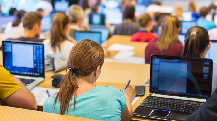 Students in class using their laptops.