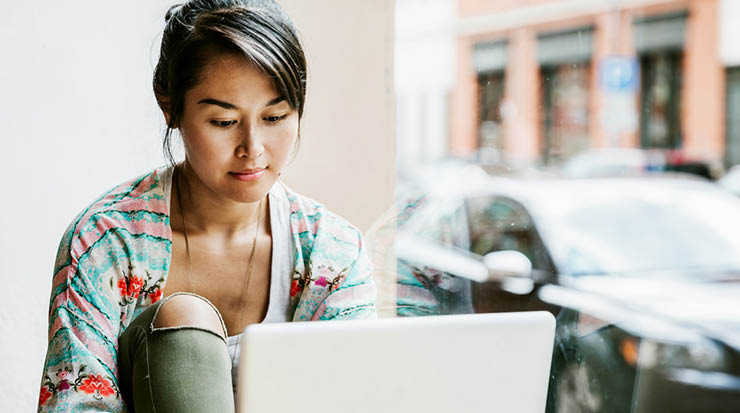 A college age student working at her laptop.