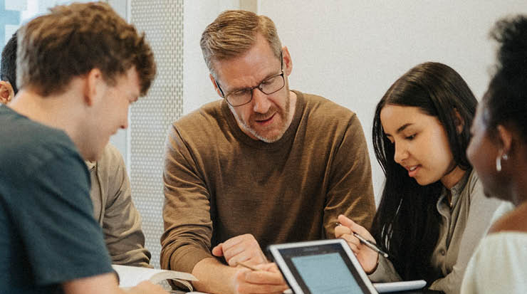 Man with glasses leading a study group
