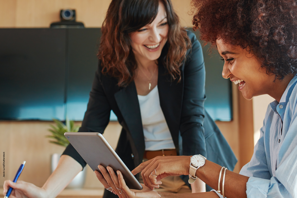 two female colleagues smiling in work setting