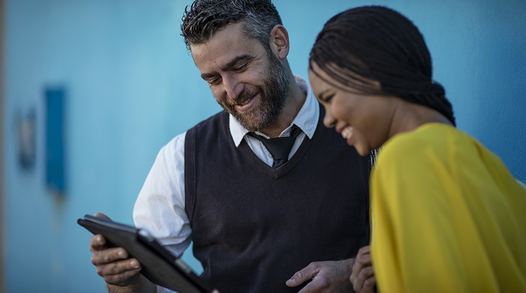 Two people looking at a tablet.
