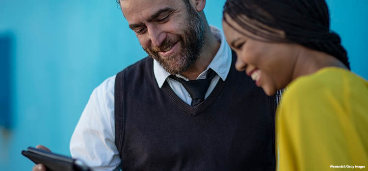 An instructor looking at a tablet with a student