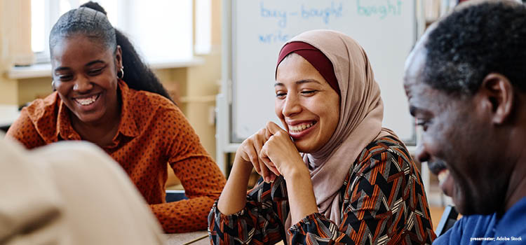 A diverse group of three students smiling
