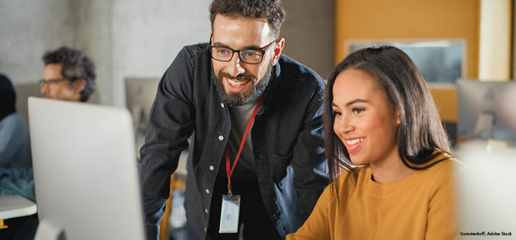 Instructor helping a student in a computer lab
