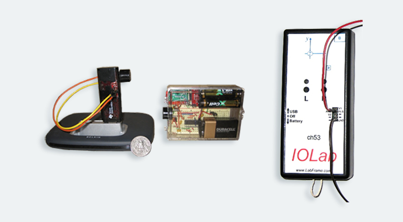 three separate objects made up of a wire setup, batteries in a circuit box, and IOLab controller