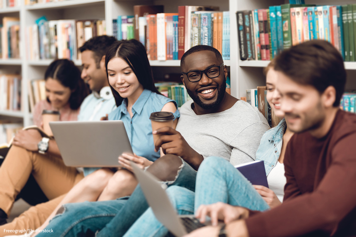 happy students sitting together in a library