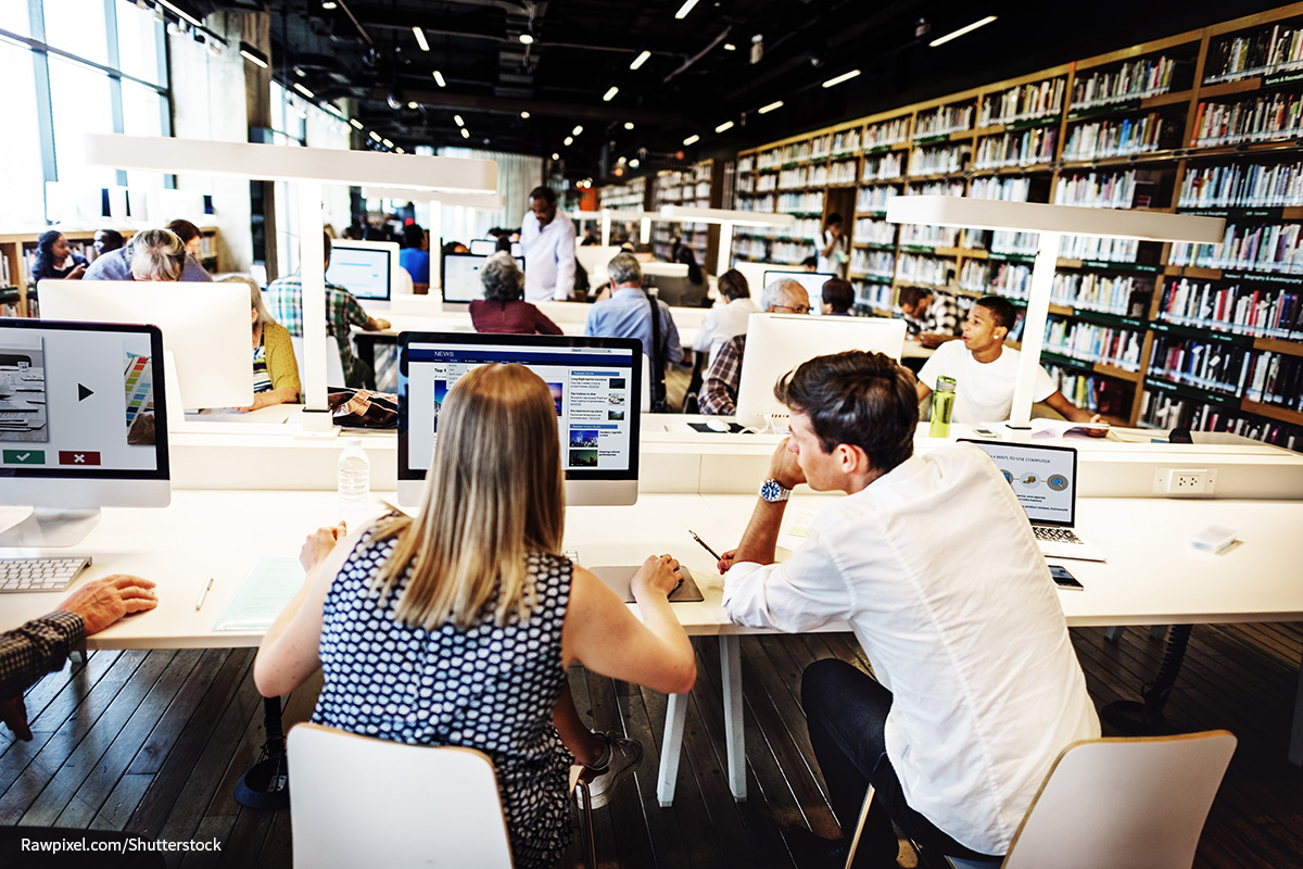 people working on computers in a library