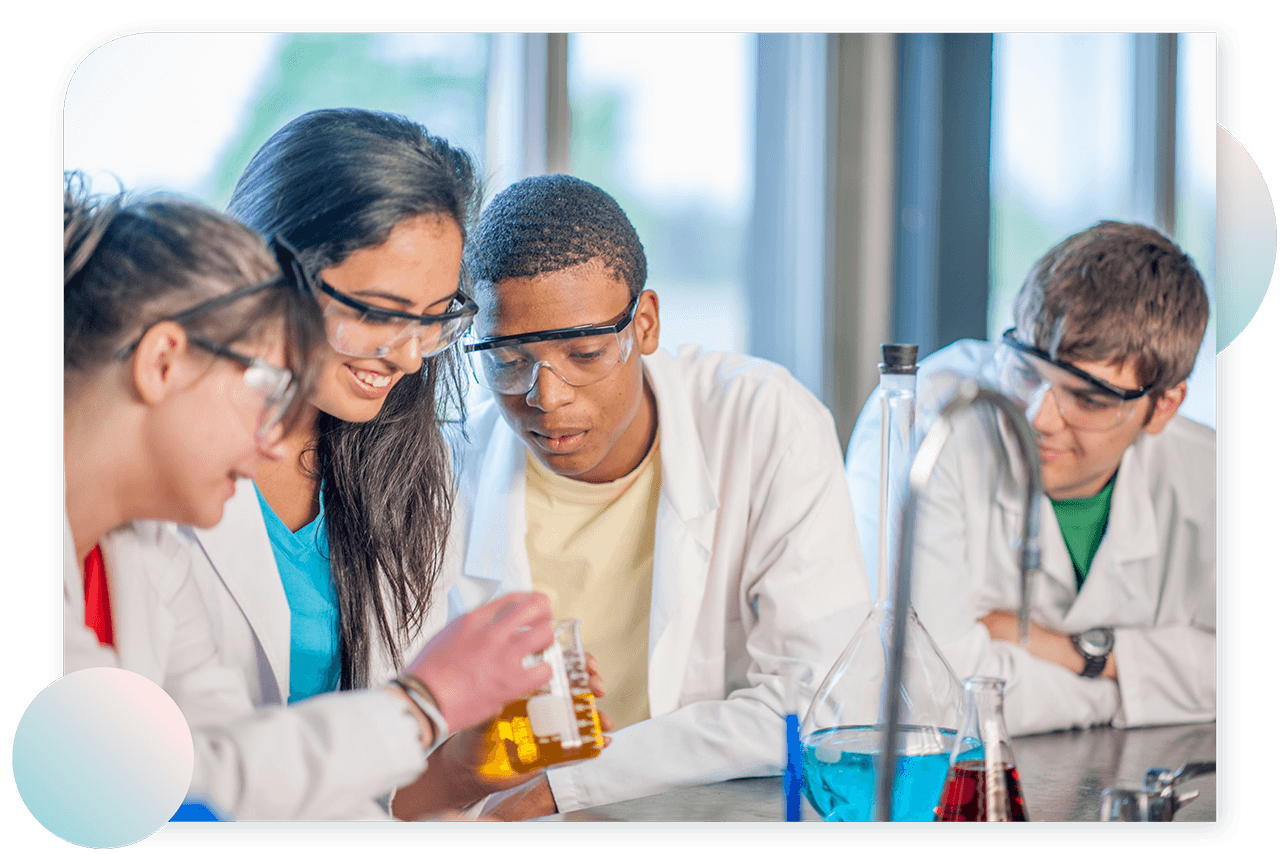 A photograph shows four students working in a Chemistry Lab. They are shown wearing Lab coats and safety glasses. The girl in the middle is holding a beaker containing a yellow solution. A volumetric flask is shown on the table in the foreground.